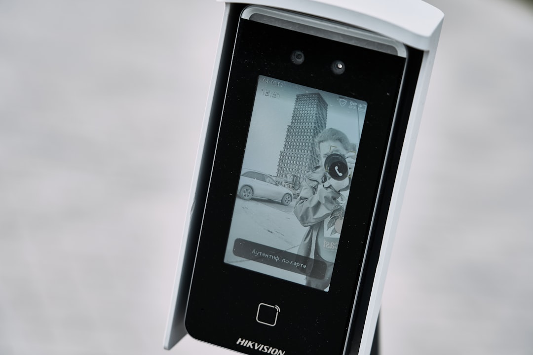 AI settlement compensation — Facial recognition device displaying a black and white image.